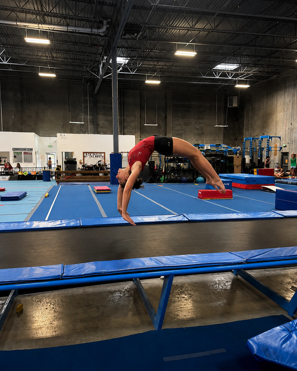 Gymnast practicing a back walkover on the floor