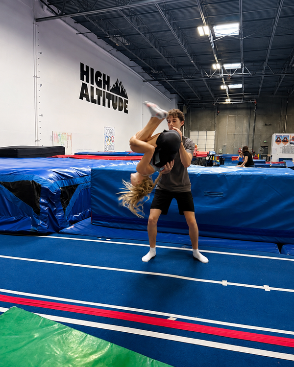 Coach spotting an athlete's back handspring on the tumble track