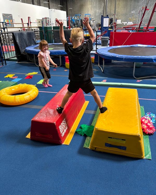Small group of toddlers playing a movement game with their coach